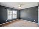 Neutral bedroom featuring a ceiling fan and a large window providing natural light at 6498 Stonelake Sw Pl, Atlanta, GA 30331