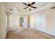 Bedroom with ceiling fan, closet with double doors, and view to the bathroom at 6498 Stonelake Sw Pl, Atlanta, GA 30331