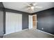 Bedroom with a ceiling fan, neutral carpet, gray walls, and a large white closet at 6498 Stonelake Sw Pl, Atlanta, GA 30331