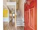 Inviting foyer featuring hardwood floors, a staircase, and a warm red front door at 6498 Stonelake Sw Pl, Atlanta, GA 30331