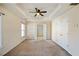 Large main bedroom with a tray ceiling, ceiling fan, and carpeted floors at 6498 Stonelake Sw Pl, Atlanta, GA 30331