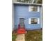 View of a two-story home with blue siding, white trim, and a red stairway to the entry door at 6950 Oakhill Se Cir, Austell, GA 30168