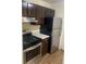 Features a stainless steel stove, vent hood, stainless steel refrigerator, and dark wood cabinets at 6950 Oakhill Se Cir, Austell, GA 30168