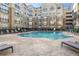 Apartment complex swimming pool surrounded by lounge chairs and landscaped grounds at 800 Peachtree Ne St # 1320, Atlanta, GA 30308