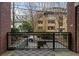 Outdoor balcony with brick walls and iron railings overlooks a tranquil street with lush greenery at 850 Piedmont Ave # 2102, Atlanta, GA 30308