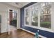 Living room with open door to balcony and large window, featuring hardwood floors and a navy accent wall at 850 Piedmont Ave # 2102, Atlanta, GA 30308