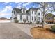 An eye-level view showcasing the home's grand entrance, driveway, and side-entry garage at 1410 Barnsley Walk, Snellville, GA 30078