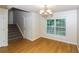Hardwood floor dining room with chandelier, window, staircase and front door at 5792 Village Loop, Fairburn, GA 30213