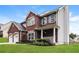 A two-story brick home featuring a manicured lawn and an attached two-car garage at 5792 Village Loop, Fairburn, GA 30213
