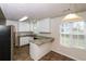 Bright kitchen features white cabinets, granite counters, modern lighting, and stainless steel appliances at 5792 Village Loop, Fairburn, GA 30213