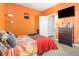 Bright orange bedroom featuring a window letting in natural light, and a comfortable bed at 2126 Sawgrass Dr, Hampton, GA 30228