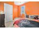 Bright orange bedroom featuring a window letting in natural light, and a comfortable bed at 2126 Sawgrass Dr, Hampton, GA 30228