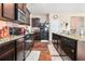Well-lit kitchen boasts granite countertops, dark wood cabinets, stainless steel appliances, and a large kitchen island at 2126 Sawgrass Dr, Hampton, GA 30228