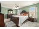 Cozy bedroom featuring green walls, carpet flooring, a ceiling fan, and classic furniture with bright bedding at 2126 Sawgrass Dr, Hampton, GA 30228