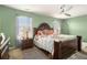 Comfortable bedroom with green walls, carpet, classic furniture, ceiling fan, and natural light from window at 2126 Sawgrass Dr, Hampton, GA 30228