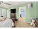 Bright green bedroom featuring carpet flooring, a ceiling fan, a TV, and access to an ensuite bathroom at 2126 Sawgrass Dr, Hampton, GA 30228