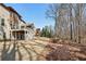 Beautiful backyard with grassy lawn and mature trees and the exterior of a brick home at 4520 Valence Dr, Cumming, GA 30040