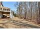 Spacious grassy backyard leads up to a staircase and patio of a multi-story brick home at 4520 Valence Dr, Cumming, GA 30040