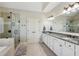 Large bathroom with a walk-in shower and a granite countertop double vanity with white cabinets at 4520 Valence Dr, Cumming, GA 30040