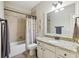 Bathroom featuring a vanity with granite countertops, tile shower, and framed mirror at 4520 Valence Dr, Cumming, GA 30040