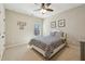Cozy bedroom features neutral walls, a ceiling fan, a double bed with patterned bedding, and natural light at 4520 Valence Dr, Cumming, GA 30040