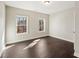 Neutral bedroom with hardwood flooring, two windows and white trim at 4520 Valence Dr, Cumming, GA 30040