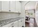 Butlers pantry featuring granite countertop that opens to dining room at 4520 Valence Dr, Cumming, GA 30040