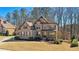 Charming two-story home featuring a brick and stone facade, manicured lawn, and mature trees adding to its curb appeal at 4520 Valence Dr, Cumming, GA 30040