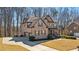 Elegant brick home with a well-manicured lawn, mature trees, and a spacious driveway at 4520 Valence Dr, Cumming, GA 30040