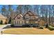 Charming two-story home featuring a brick and stone facade, manicured lawn, and mature trees adding to its curb appeal at 4520 Valence Dr, Cumming, GA 30040