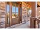 Inviting entryway showcasing a wood door with glass panels, complemented by stone and brick accents at 4520 Valence Dr, Cumming, GA 30040