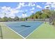 Outdoor tennis court featuring new lighting, landscaping, and a green and blue surface at 4901 Village Green Dr, Roswell, GA 30075