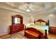 Well lit bedroom with tray ceiling, warm tones, and wood furniture and flooring at 3889 Pineybrook Dr, Loganville, GA 30052