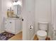 Bathroom with white vanity, toilet, and dark gray rug on light-colored wood floors at 551 Lees Mill Rd, Fayetteville, GA 30214