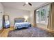 A cozy bedroom featuring light wood floors, a window, and a soft gray rug at 551 Lees Mill Rd, Fayetteville, GA 30214