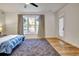 Bright bedroom with a large window, gray rug, and a ceiling fan at 551 Lees Mill Rd, Fayetteville, GA 30214