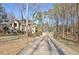 Long driveway leading up to a tan stucco home surrounded by lush trees at 551 Lees Mill Rd, Fayetteville, GA 30214