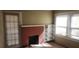 Cozy living room featuring a classic fireplace, built-in shelving, and natural light from the windows at 1497 Clermont Ct, Atlanta, GA 30344