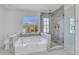 Bright bathroom features soaking tub and glass enclosed shower with marble surround and natural light at 2250 Deer Oaks Trl, Lawrenceville, GA 30044