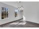 Bright dining room featuring a modern light fixture, fresh white paint, and gray wood flooring at 2250 Deer Oaks Trl, Lawrenceville, GA 30044