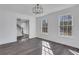 Bright dining room featuring a modern light fixture, fresh white paint, and gray wood flooring at 2250 Deer Oaks Trl, Lawrenceville, GA 30044