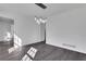 Bright dining room featuring a modern light fixture, fresh white paint, and gray wood flooring at 2250 Deer Oaks Trl, Lawrenceville, GA 30044