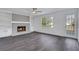 Inviting living room features a decorative fireplace with white built-ins, a ceiling fan, and grey wood flooring at 2250 Deer Oaks Trl, Lawrenceville, GA 30044