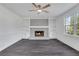 Inviting living room features a decorative fireplace with white built-ins, a ceiling fan, and grey wood flooring at 2250 Deer Oaks Trl, Lawrenceville, GA 30044