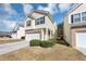 Two story home featuring yellow siding, brick facade, attached garage and well maintained yard at 6462 Splitpine Ct, Atlanta, GA 30349