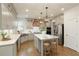 A modern kitchen with stainless steel appliances, light gray cabinets, white countertops, and a central island with seating at 3560 Pleasant Grove Rd, Cumming, GA 30028