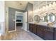 Beautiful bathroom featuring a double vanity, modern mirrors, stone accent wall and hardwood floors at 5809 Savannah River, Atlanta, GA 30349