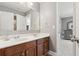 Bathroom featuring double sinks, mirrors, vanity and doorway view into bedroom at 149 Manor Lane, Woodstock, GA 30188