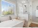 Bright bathroom featuring a soaking tub, a shower, and a large window at 149 Manor Lane, Woodstock, GA 30188