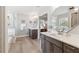 Bright bathroom featuring double sinks, mirrors, vanity and view of soaking tub and shower at 149 Manor Lane, Woodstock, GA 30188